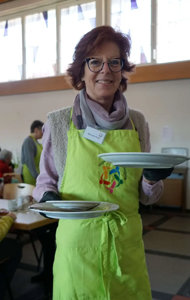 Ehrenamtliche Manuela Picco räumt das gebrauchte Geschirr ab.