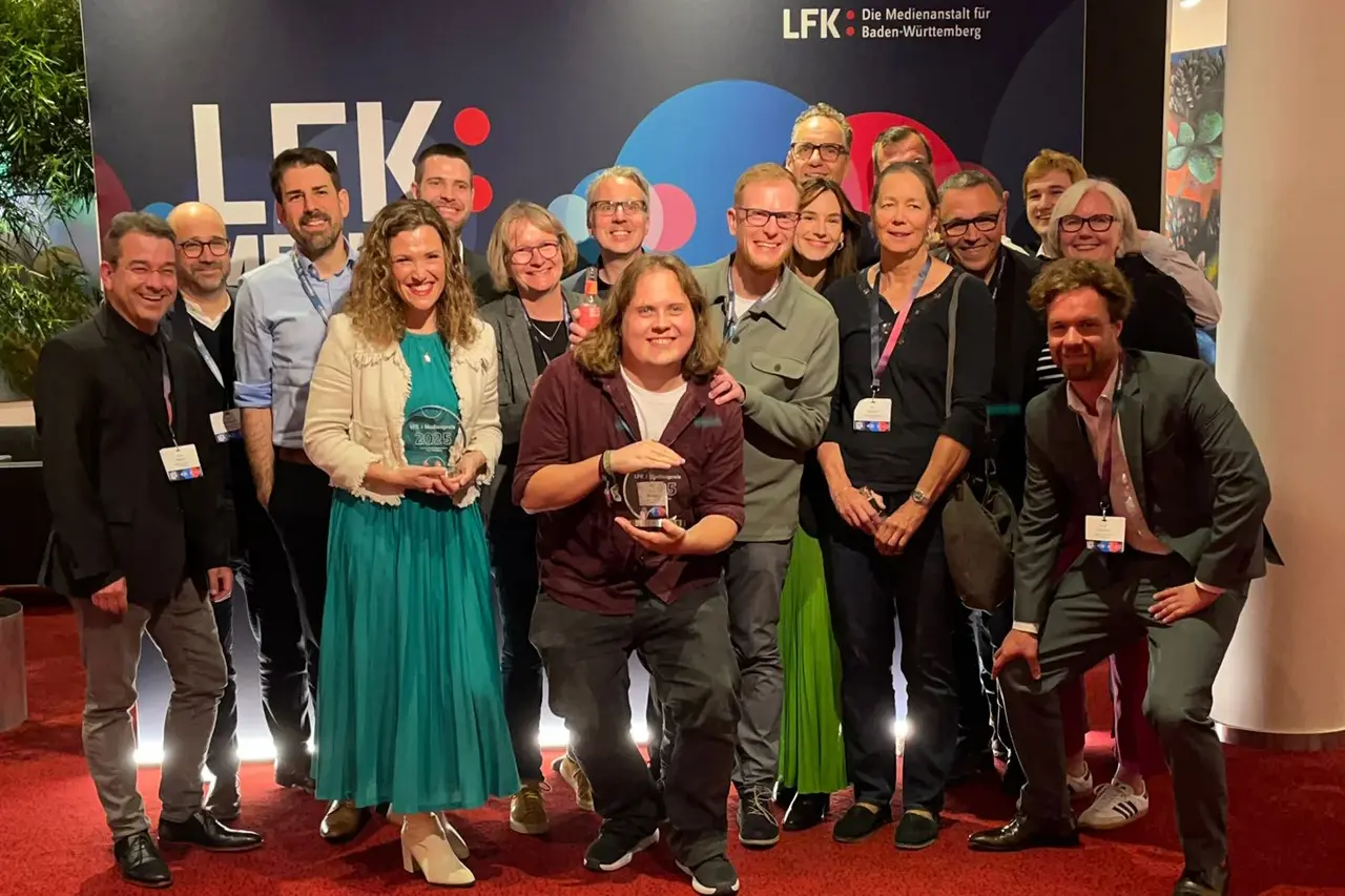 Das Team des Ev. Medienhauses mit Gästen. Vorne mit Preisen: Juliane Eberwein und Claudio Murmann, die den Preis entgegengenommen haben.