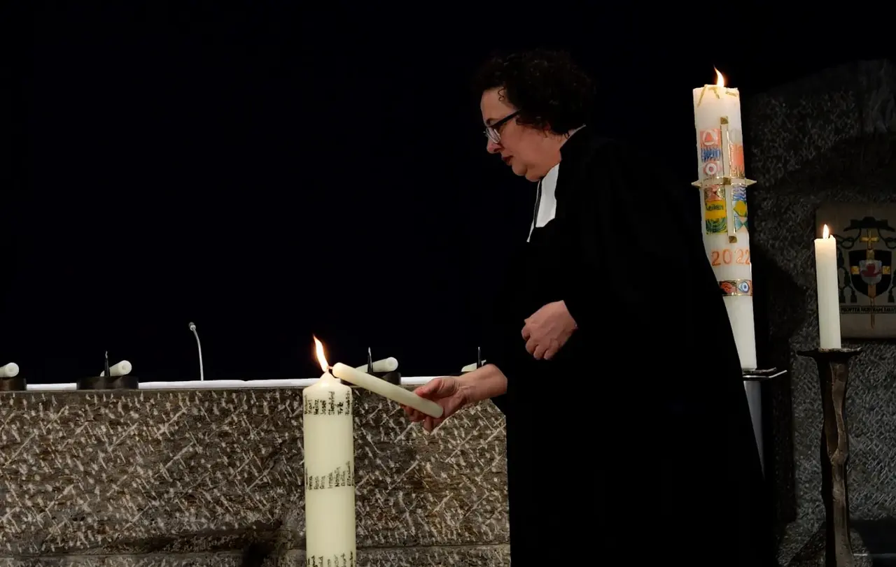 Silke Stürmer im ökumenischen Gedenkgottesdienst am 15. März 2023. Auf der großen Kerze am Boden stehen Namen der Kinder, die deportiert wurden. Sie wurde von den Schülerinnen und Schülern der Bischof von Lipp-Schule in Mulfingen gestaltet und in die Kirche getragen.