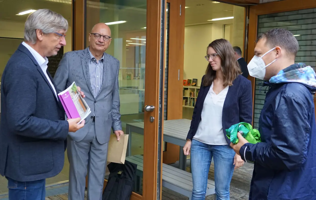 „Im Austausch überreichten (von links) Klaus-Peter Koch und Georg Eberhardt die Broschüre Klimaschutz - als Kirche aktiv sein“ an Johanna Baumgarten und Moritz Riedacher.