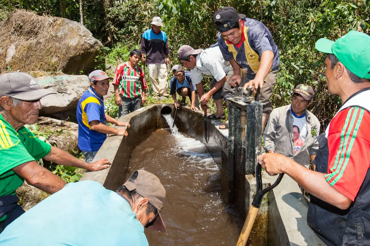 Kleinbauern setzen ein Rückhaltebecken instand.