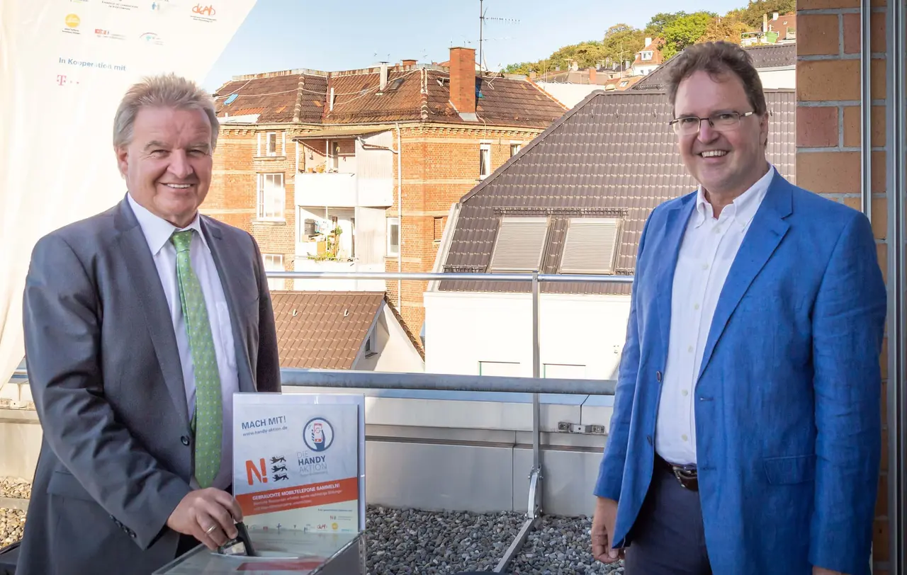 Umweltminister Franz Untersteller (links) gratuliert Pfarrer Ralf Häußler und den weiteren Aktiven der Handy-Aktion Baden-Württemberg zu mehr als 100.000 gesammelten Handys.