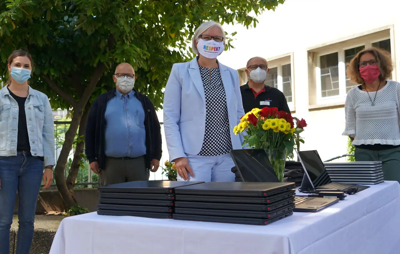 Gruppenbild mit 20 Computern: Sabine Foth (Mitte) übergab die PCs im Namen der Landessynode an die Evangelische Kirchengemeinde Wangen. Im Sicherheitsabstand und mit Maske dabei (von rechts): Jugendreferentin Heike Ulrich, Ivan Frick von „Data Group“, KGR-Vorsitzender Michael Mischke und Stefanie Dorsch vom Jugendamt HzE.