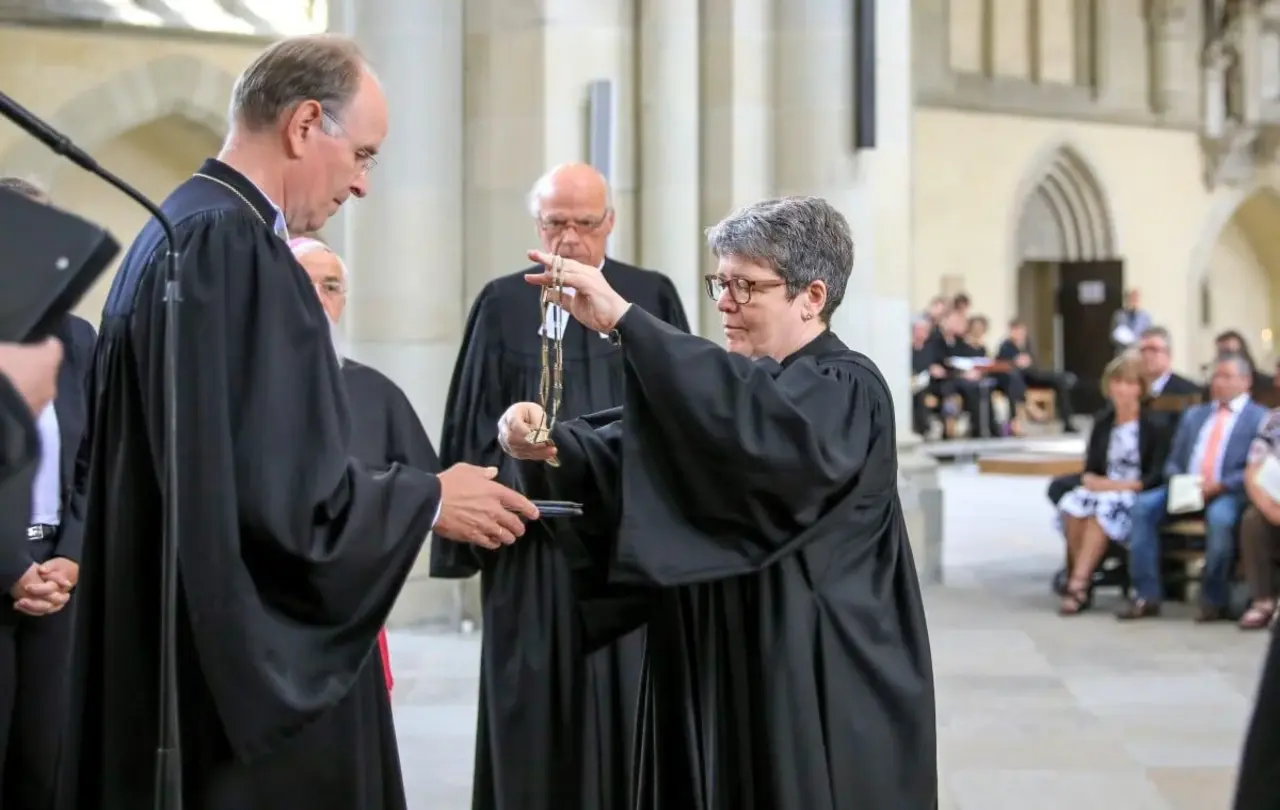 Ilse Junkermann legt ihr Bischofskreuz ab und übergibt es dem Leitenden Bischof der Vereinigten Evangelisch-Lutherischen Kirche Deutschlands (VELKD), Landesbischof Ralf Meister aus Hannover (l.). Im Hintergrund der katholische Bischof Gerhard Feige und der Altbischof der Nordkirche, Gerhard Ulrich.
