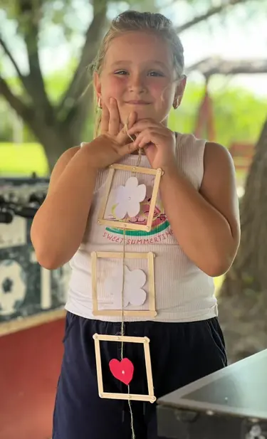 Eine junge Freizeitteilnehmerin freut sich über ihr selbst gefertigtes Geschenk.