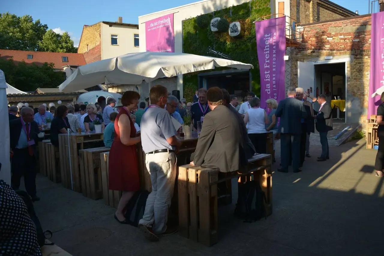 Volles Haus auch vor der Halle in Wittenberg. Im Hintergrund die horizontal wachsenden Bäume.