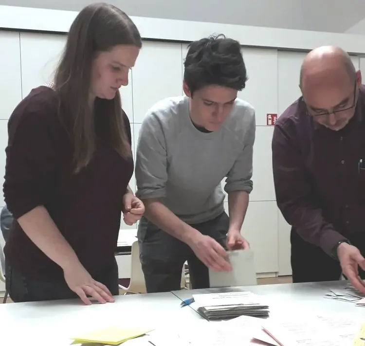 Vor dem Auszählen müssen die Helferinnen und Helfer die Stimmzettel sortieren.