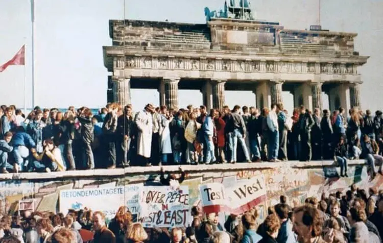 Feiernde Menschen auf der Berliner Mauer 1989.