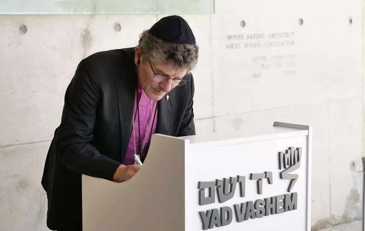 Nach der Kranzniederlegung in der Halle hat sich der Landesbischof mit dem Vers aus Sacharja 2,12 in das Gästebuch eingetragen: „Wer euch antastet, tastet Gottes Augapfel an.“