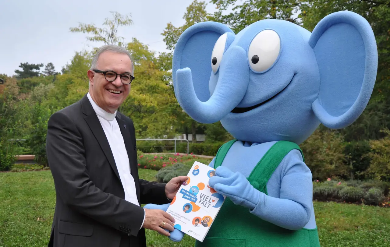 Elefant Emso überreicht Landesbischof July Materialheft „VIELFALT“