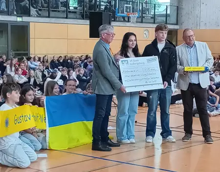 Bei der symbolischen Scheckübergabe von Rektor Helmut Dinkel (rechts) an GAW-Projektleiter Ulrich Hirsch (links) assistieren Schulsprecherin Meltem Sari (2. von links) und Sport-LK-Sprecher Alexander Püttmann (2. von rechts).