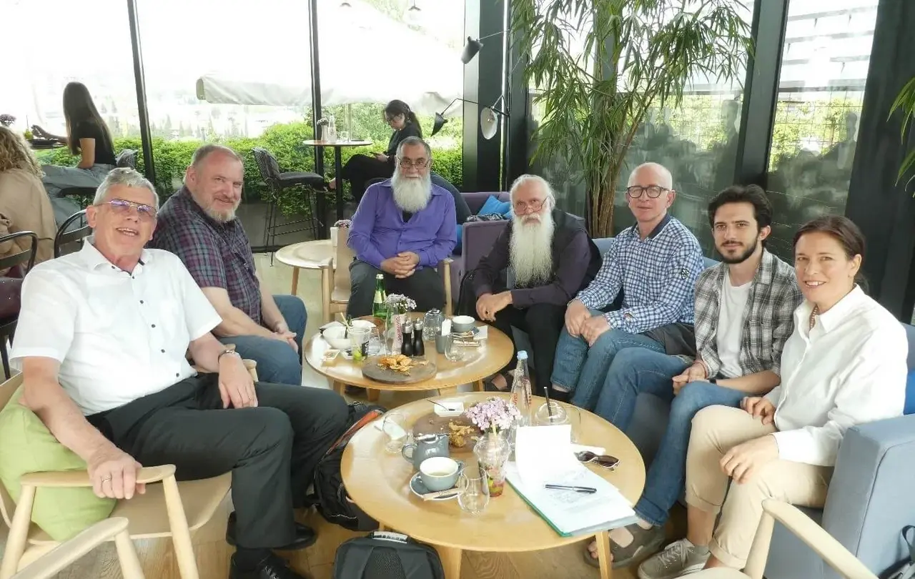 Besprechung zur Übersetzung der Erklärungsbibel 2023 ins Georgische. Von links nach rechts: Ulrich Heckel, Rolf Bareis, Bishop Ilia Osepashvili (Ev. Baptist Church of Georgia), Metropolitan Bishop Prof. Dr. Malkhaz Songulashvili (Evangelical Baptist Church of Georgia, Ilia State University, Georgische Bibelgesellschaft), Abtandil Guruli (Georgische Bibelgesellschaft), Stud. Theol. Mate Saralishvili (Ev. Baptist Church of Georgia), Susanne Schenk. Im Vordergrund die Skizze des Memorandum of Agreement über den Start des Projekts, das später von allen unterzeichnet wurde. Osepashvili und Saralishvili werden die ersten Texte übersetzen. Kooperationspartner sind: die Georgische Bibelgesellschaft, die Ilia State University, die Evangelisch-Lutherische Kirche in Georgien und dem Südlichen Kaukasus und die Evangelical Baptist Church of Georgia.