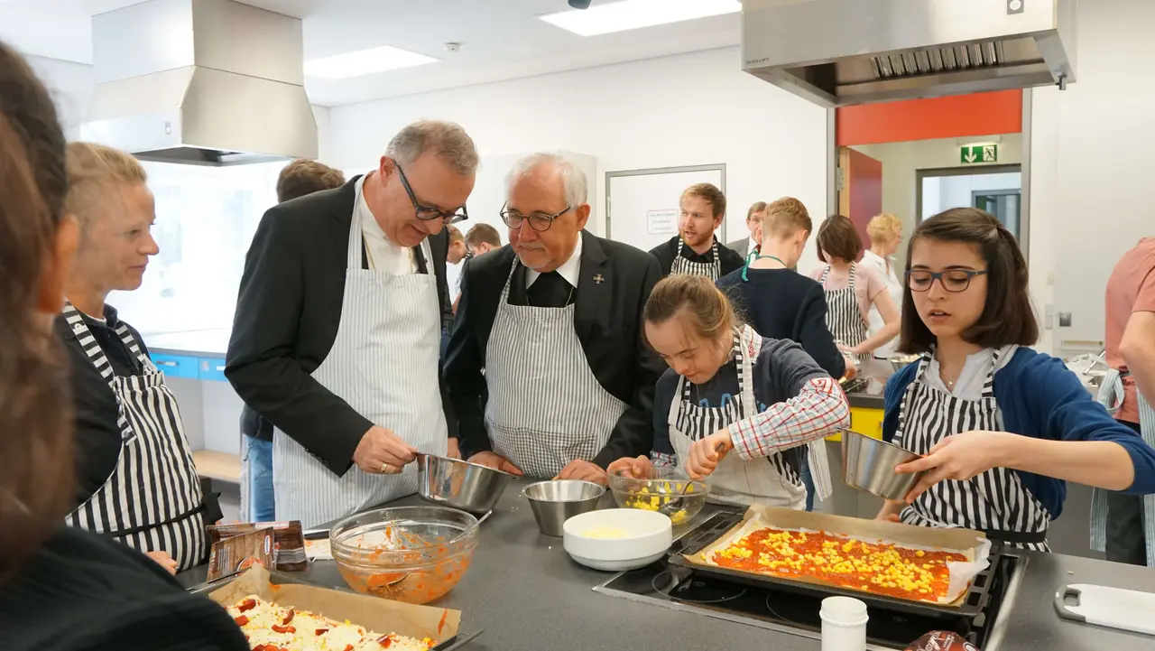 Landesbischof July und Bischof Fürst backen mit den Schülerinnen und Schülern gemeinsam Pizza.
