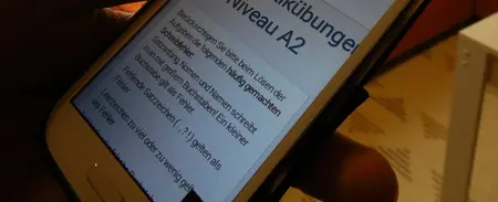 Mit seinem Smartphone kann Jned Ossi Deutsch lernen.