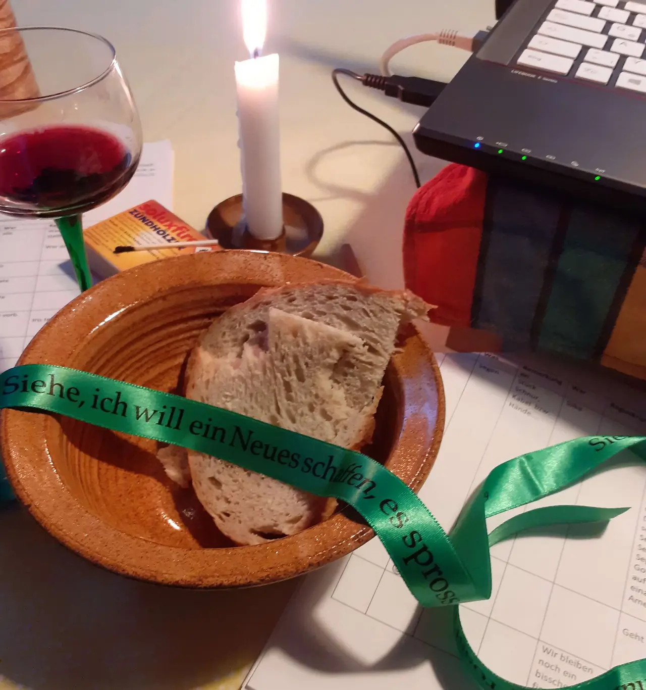 Auf ihrem Schreibtisch hält Pfarrerin Ellenberger bereit, was sie für kirche@home braucht: Brot, Wein, ein Band, eine Kerze, Laptop und ihren Ablaufplan.